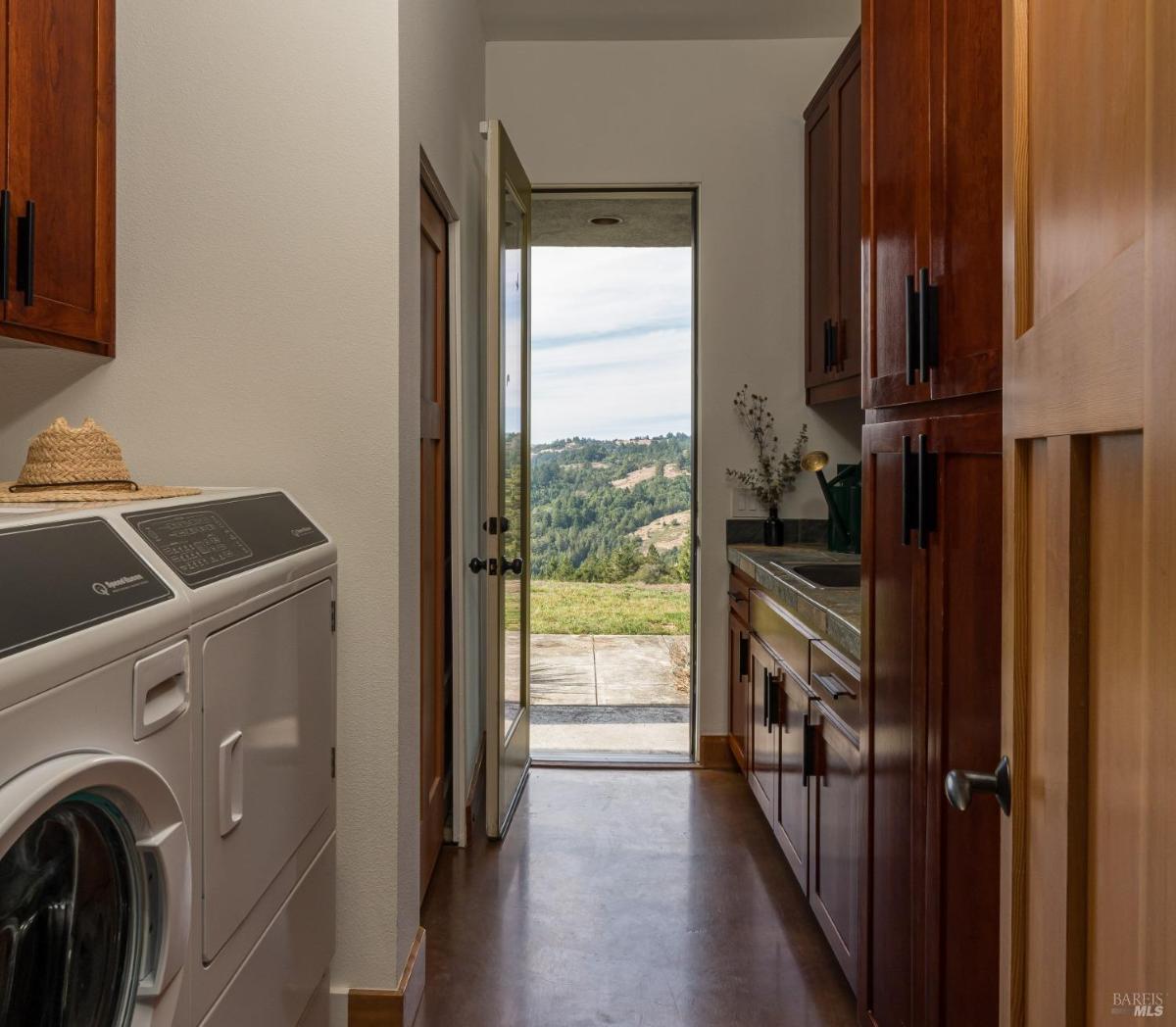 Laundry room with washer, dryer, cabinets, and an exterior door.
