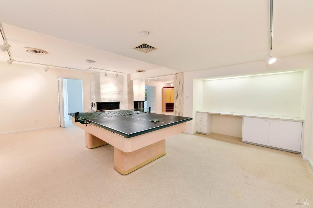 Game room with a ping pong table and fireplace.