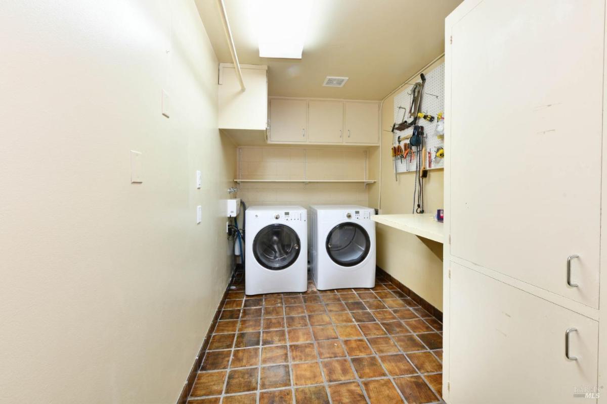 Laundry room with washer, dryer, and storage cabinets.