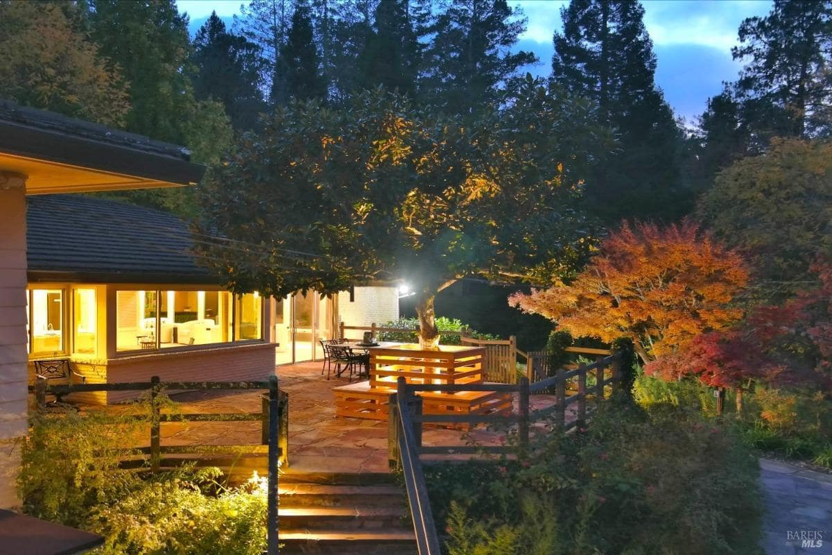 Evening view of patio and home with exterior lighting.