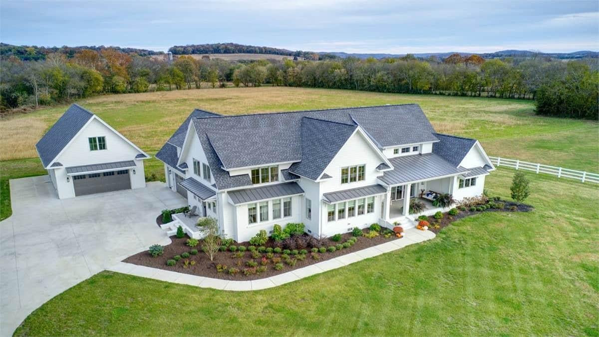 Classic White Farmhouse with a Detached Garage in a Serene Countryside Setting