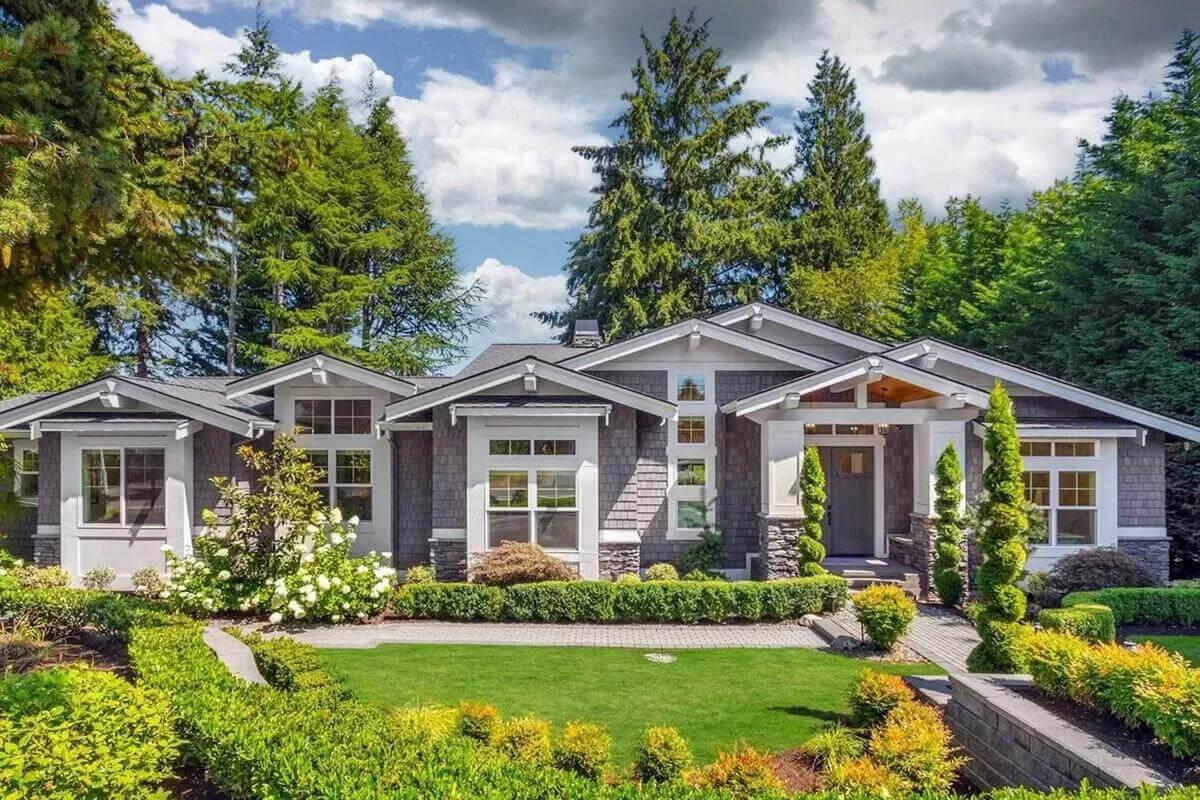 Craftsman Home Nestled Among Lush Greenery with Striking Gable Roofs