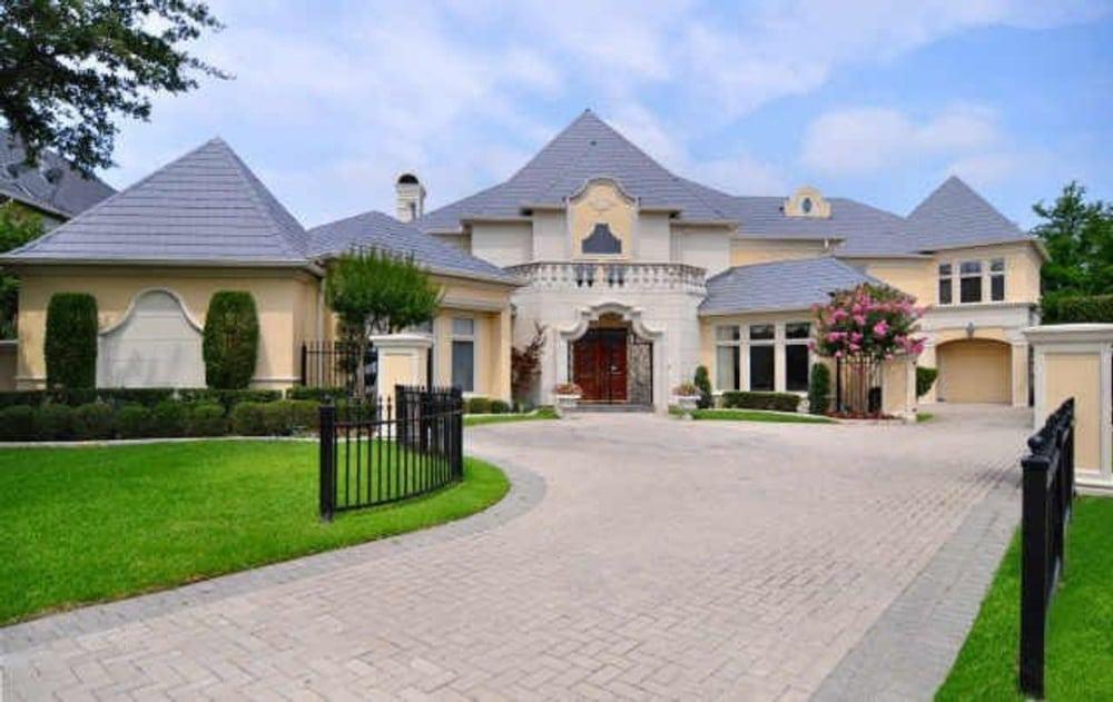 Elegant Mansion with a Grand Entrance Flanked by Manicured Gardens