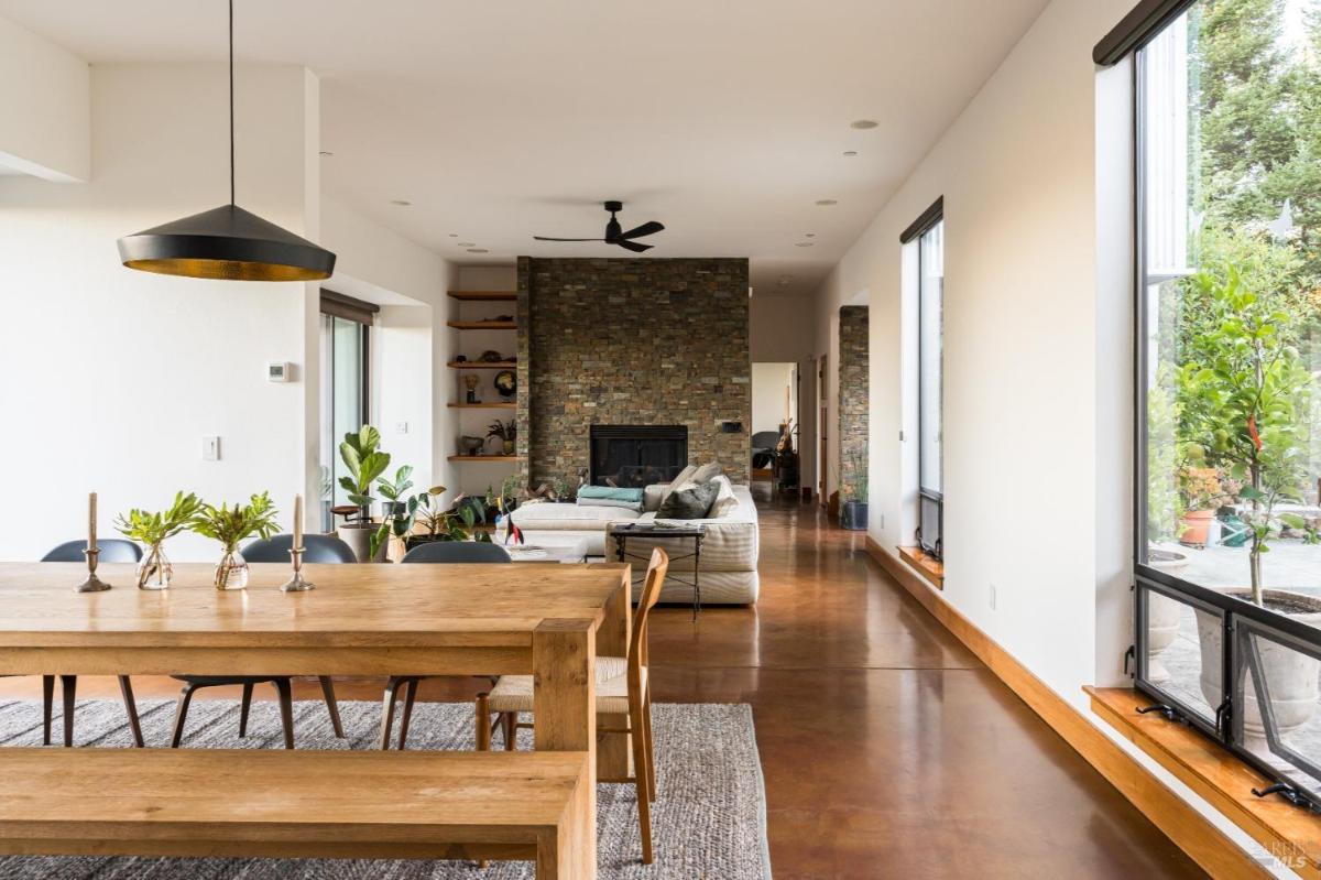 Open-plan layout showing dining table, living room, and fireplace.