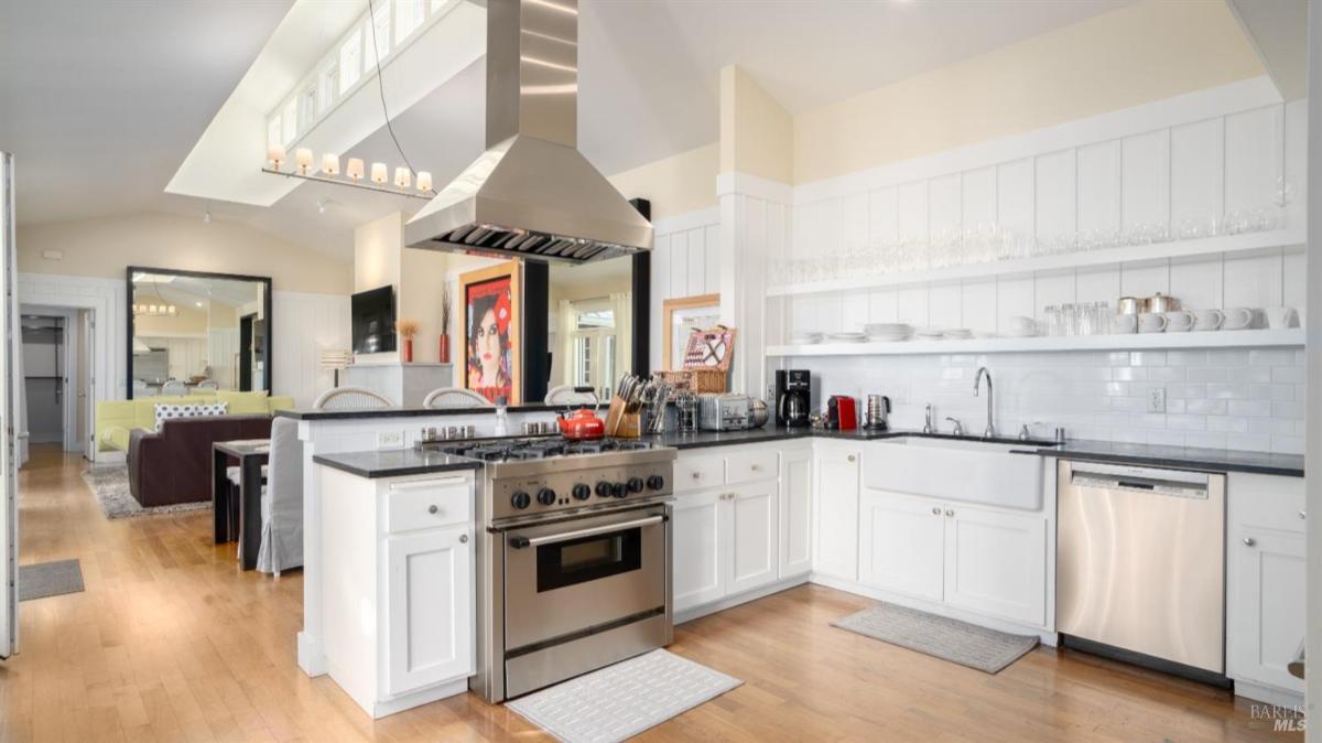 White kitchen featuring a farmhouse sink and stainless steel refrigerator.