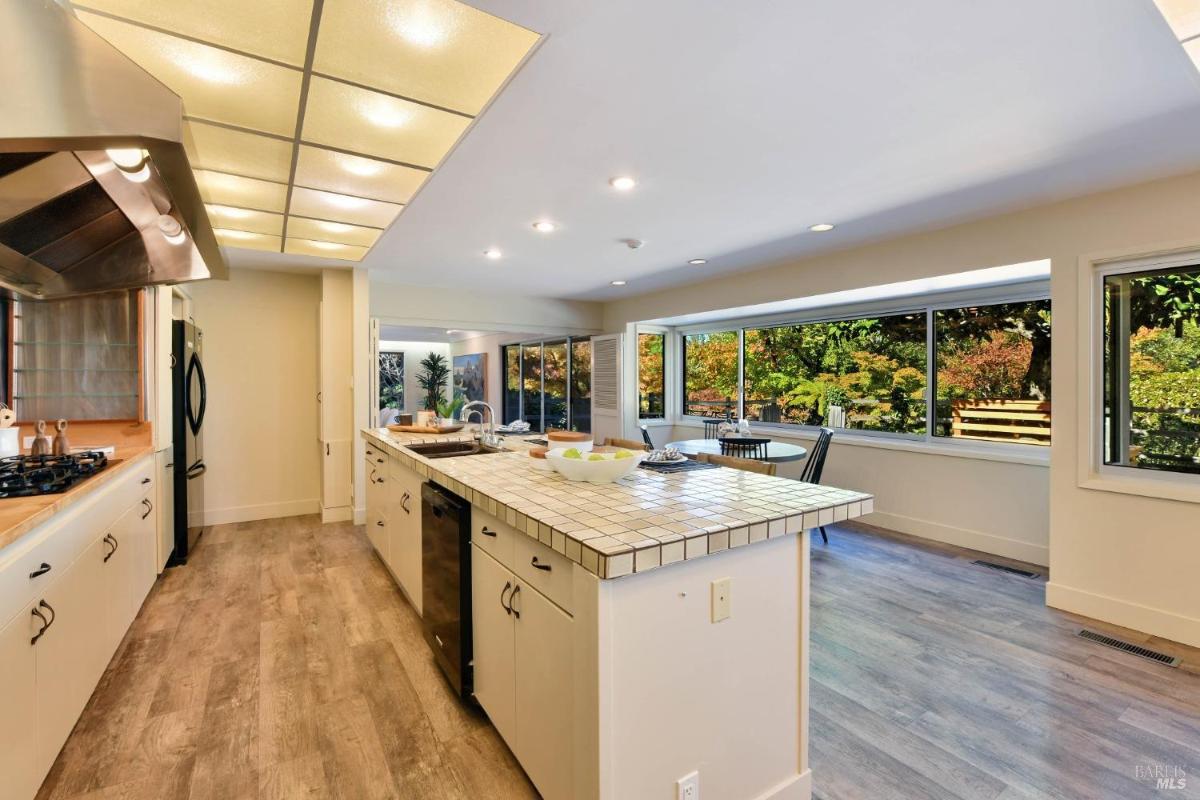 A kitchen with an island, built-in appliances, and a view of the backyard.