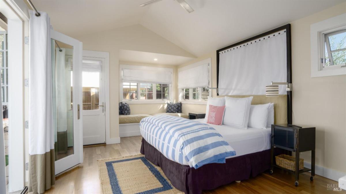Bedroom with a vaulted ceiling, bed, and built-in bench seating.