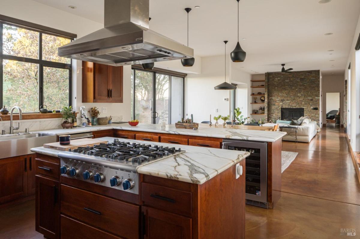 View of stove, marble countertops, and large windows.