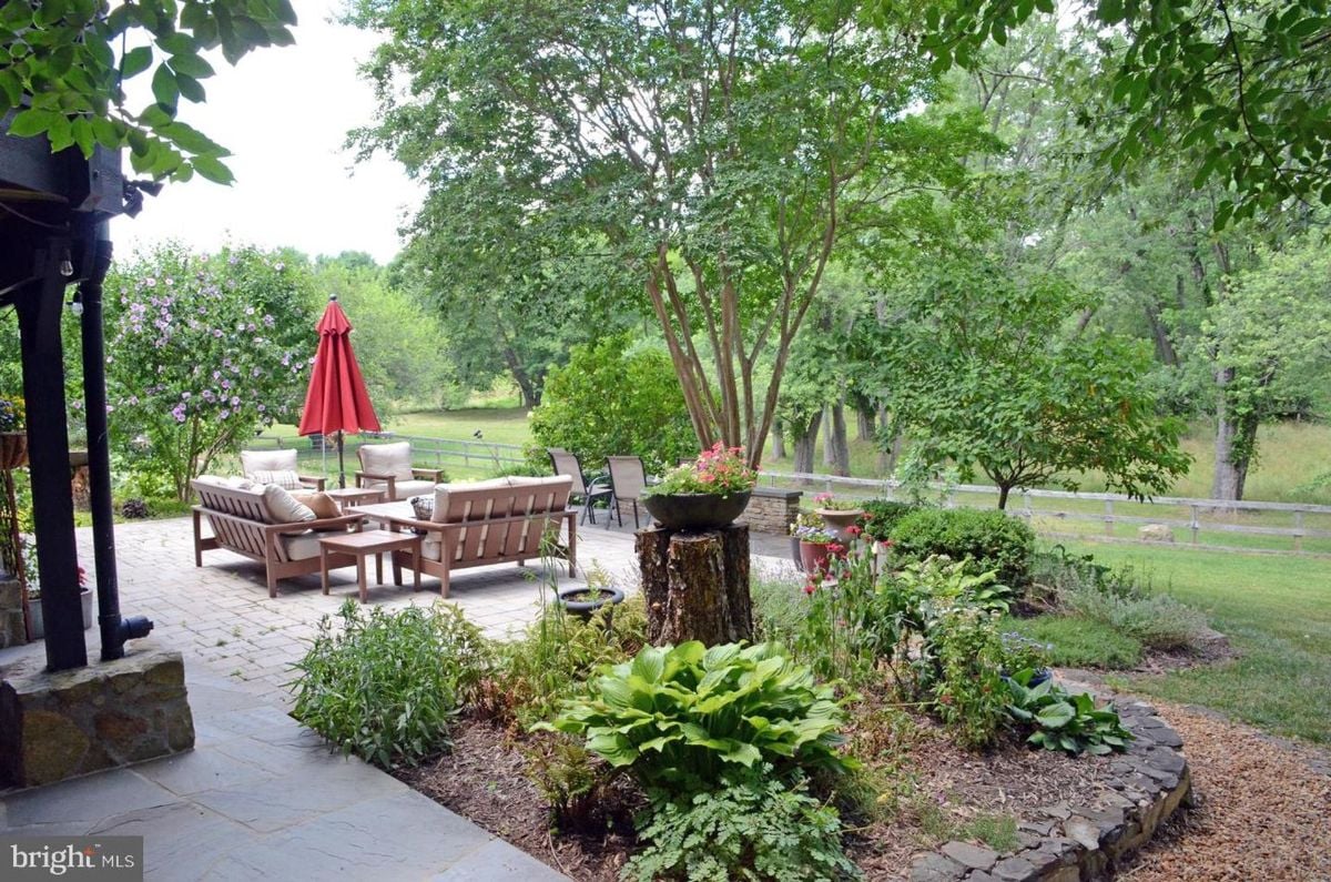 Vibrant garden patio blending greenery with stone pavers and bright outdoor seating.