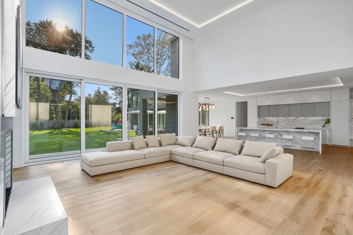 Open-concept layout connects the living room to the sleek kitchen and dining area, all bathed in natural light.