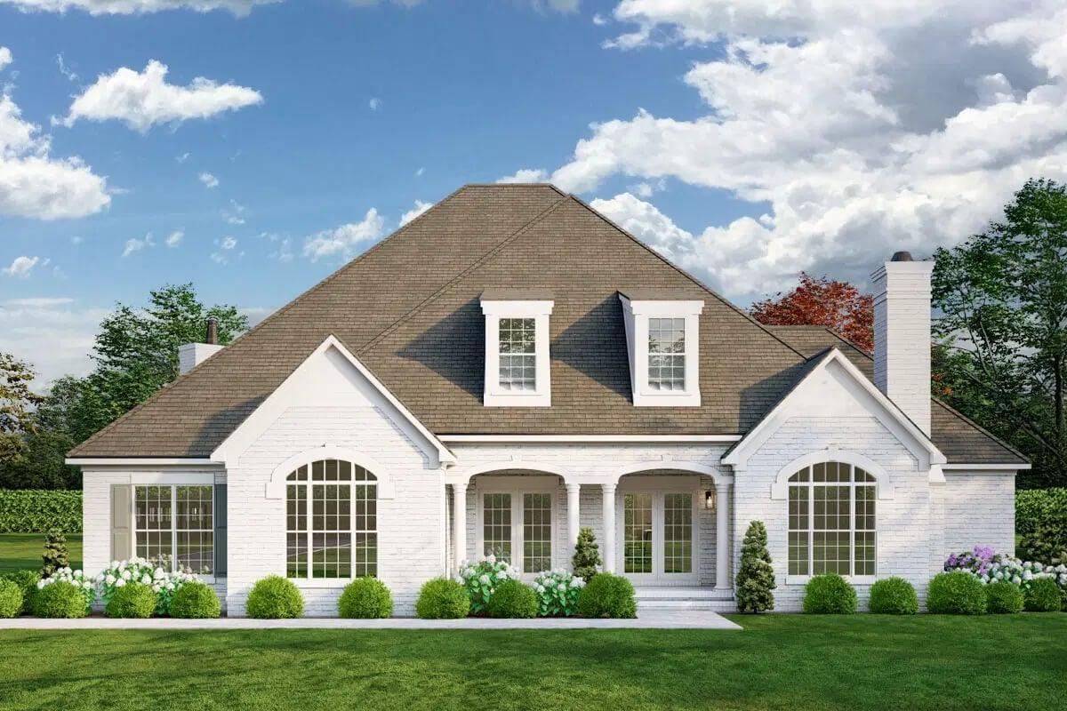Classic Brick Facade with Dormer Windows and Manicured Shrubs