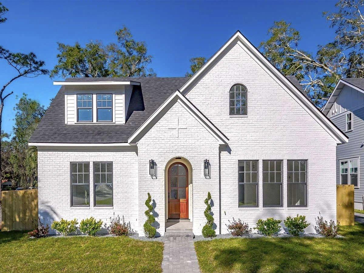 Classic White Brick Cottage with Dormer and Arched Doorway