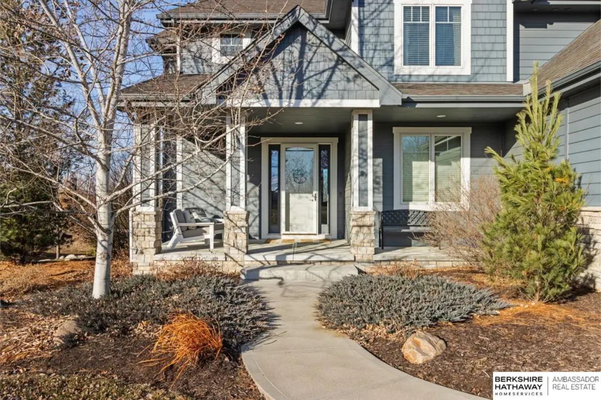 Two-story home with a welcoming front porch, stone accents, and detailed craftsmanship.