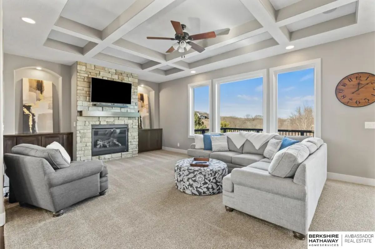 Living room with coffered ceilings and large windows showcasing scenic outdoor views.