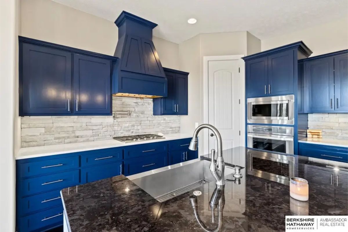 A bold navy cabinetry paired with sleek stainless steel appliances.