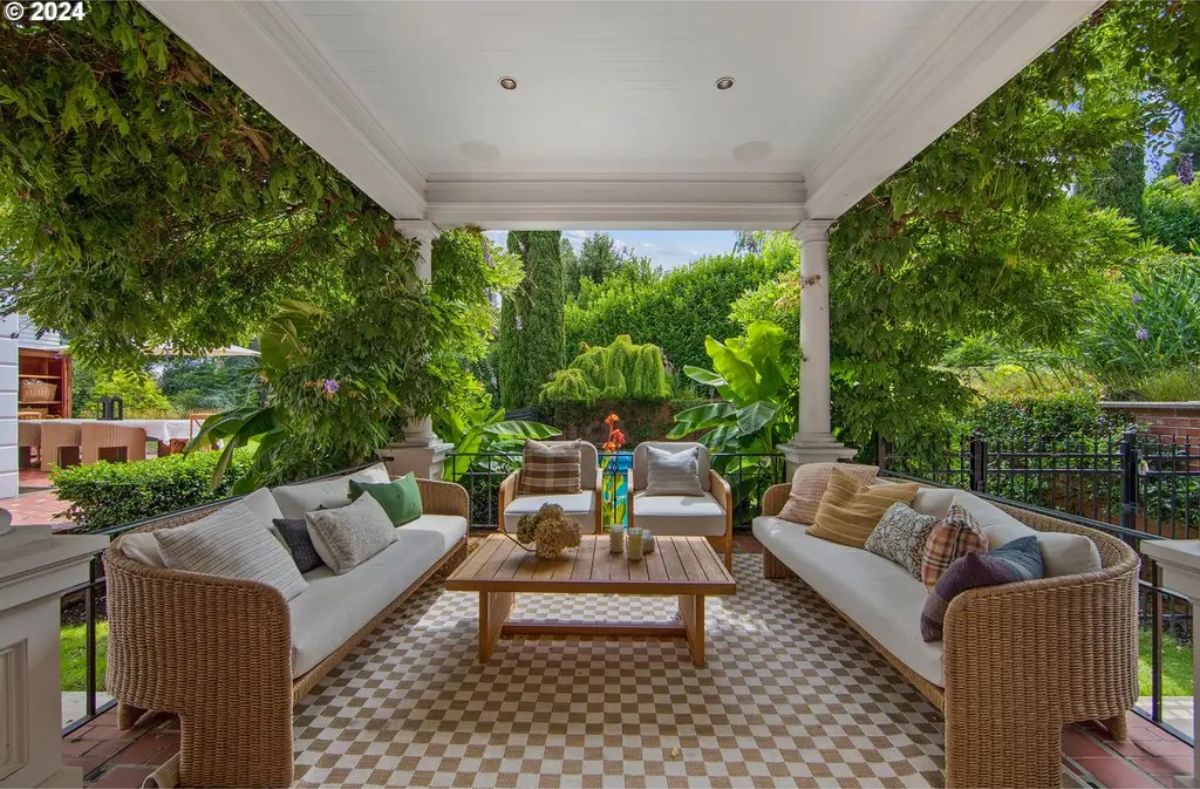 Outdoor patio features wicker seating with neutral cushions arranged around a wooden coffee table.