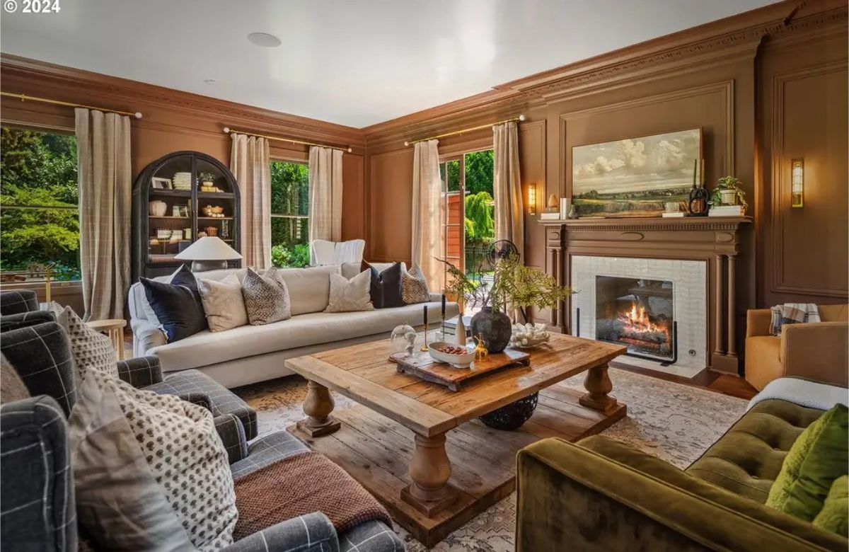 Living room features rich brown walls, detailed crown molding, and a classic fireplace with a tiled surround.