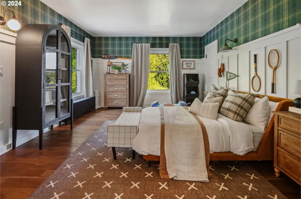 Bedroom combines traditional design elements with playful details, featuring green plaid wallpaper and white wainscoting.