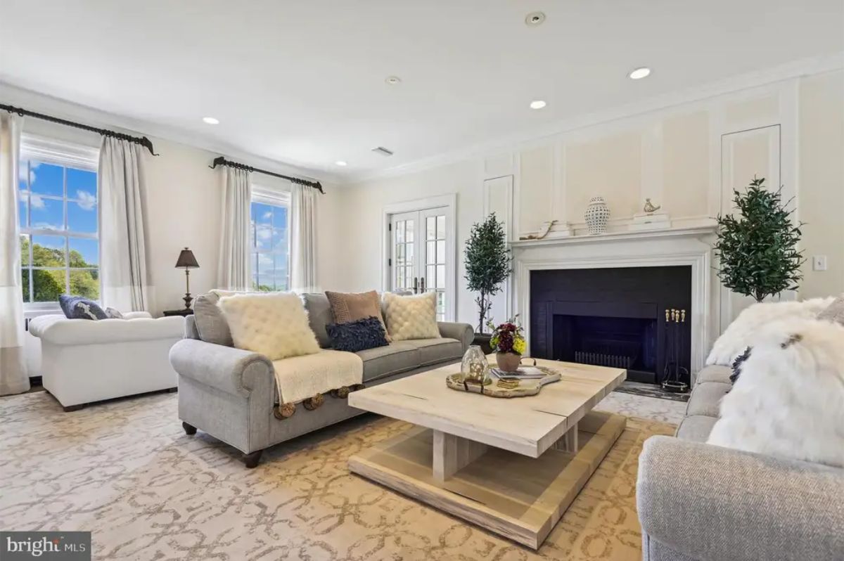 Airy living room with large windows framed by light curtains, offering scenic outdoor views.