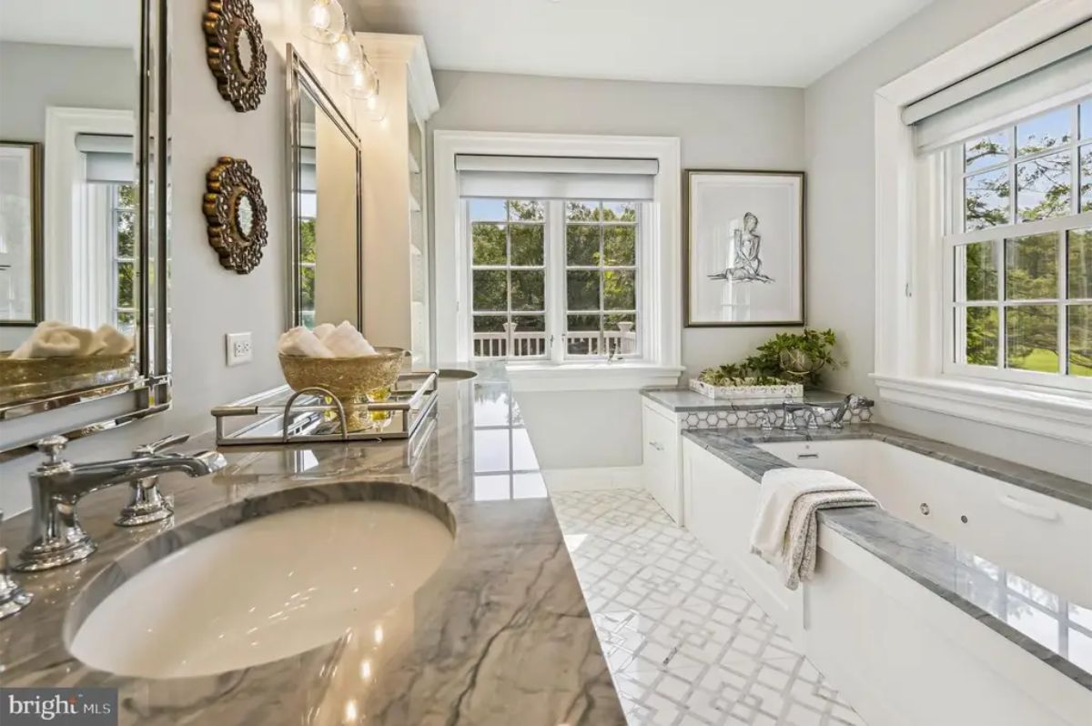 A marble countertop vanity and a built-in soaking tub with matching marble accents.