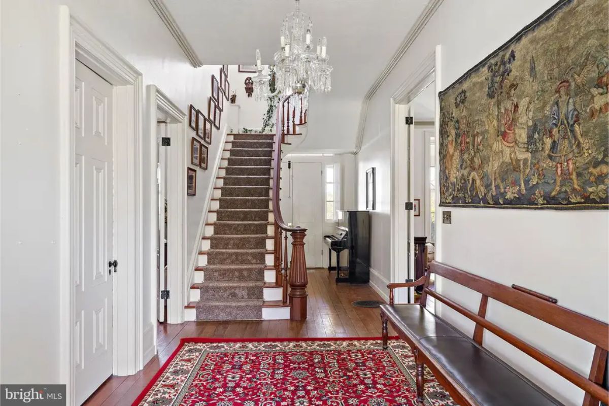Hallway showcasing a curved wooden staircase with a decorative newel post.