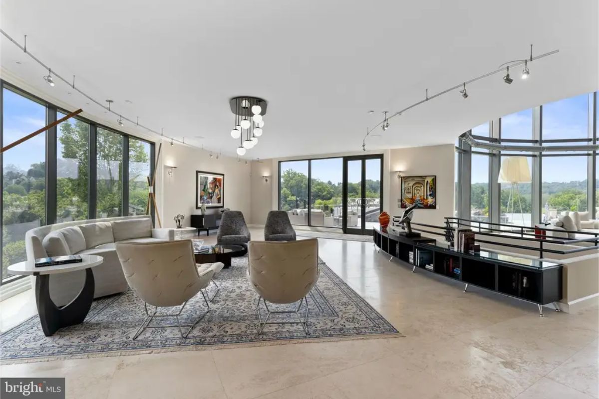 Open-concept living room with multiple seating options, minimalist design, and large balcony 