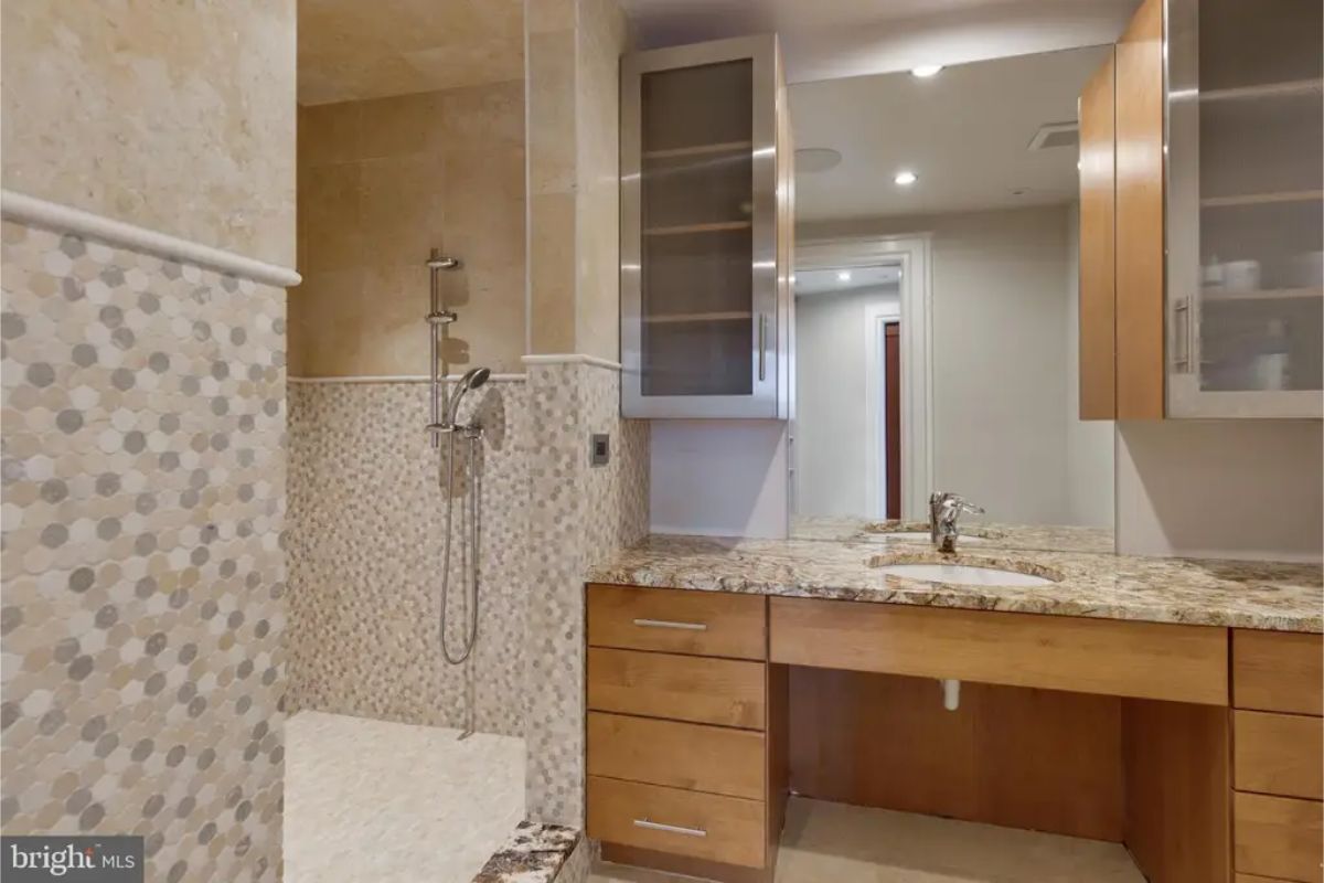 Bathroom features a walk-in shower with mosaic tiles and granite countertops. 