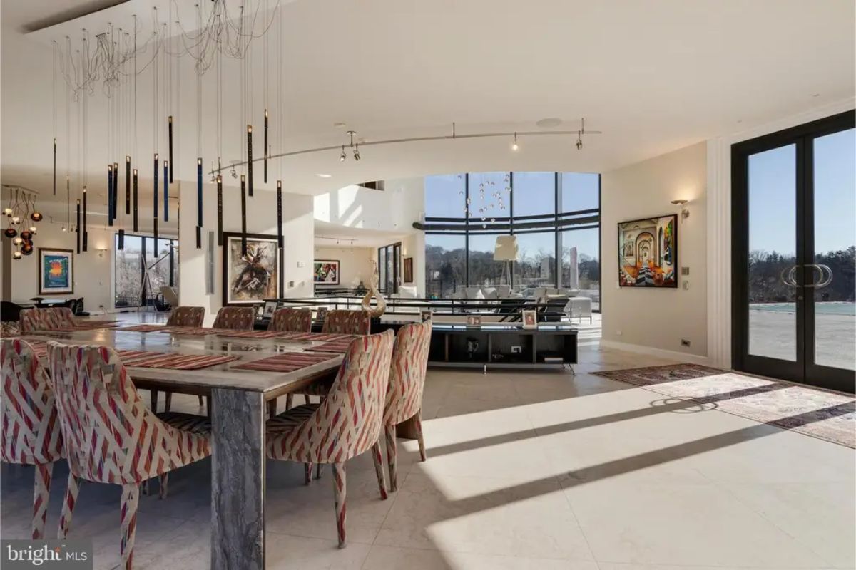 Dining area includes modern hanging light fixtures and direct access to the outdoor patio through glass doors. 