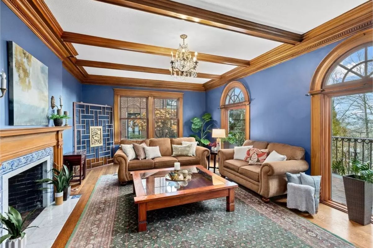 Rich blue walls complemented by warm wooden accents, including detailed crown moldings and exposed beams.