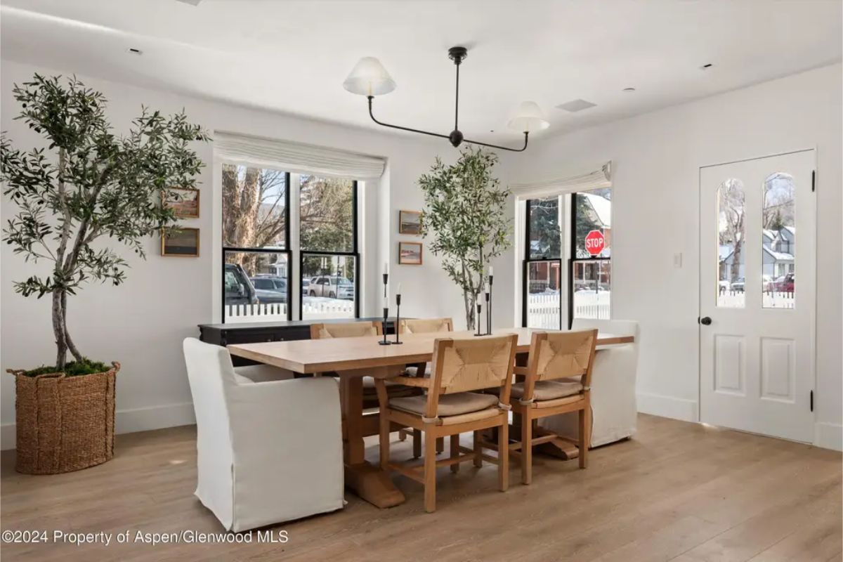 Minimalist design with clean lines and ample natural light streaming through large black-framed windows.