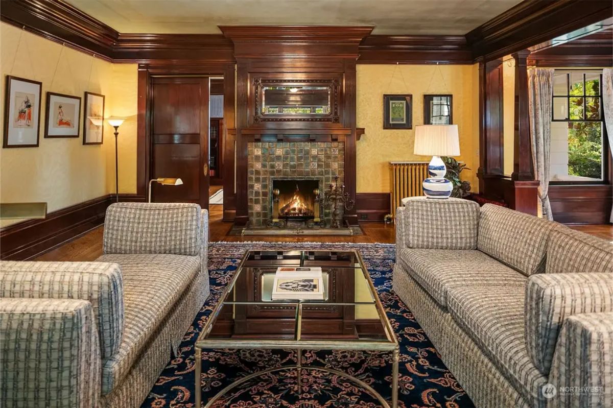 Living room showcases a central fireplace with decorative tile surround and a detailed wood mantel.