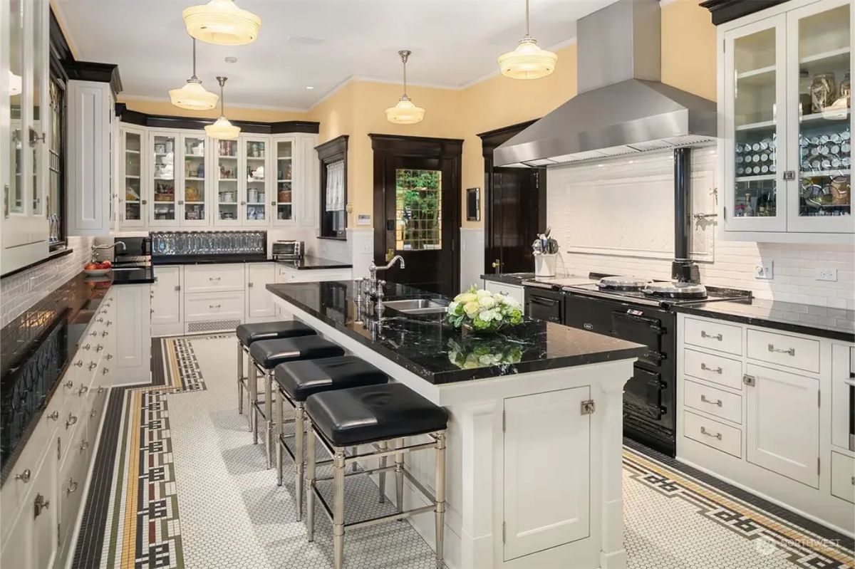 Black granite countertops on an island with barstool seating.