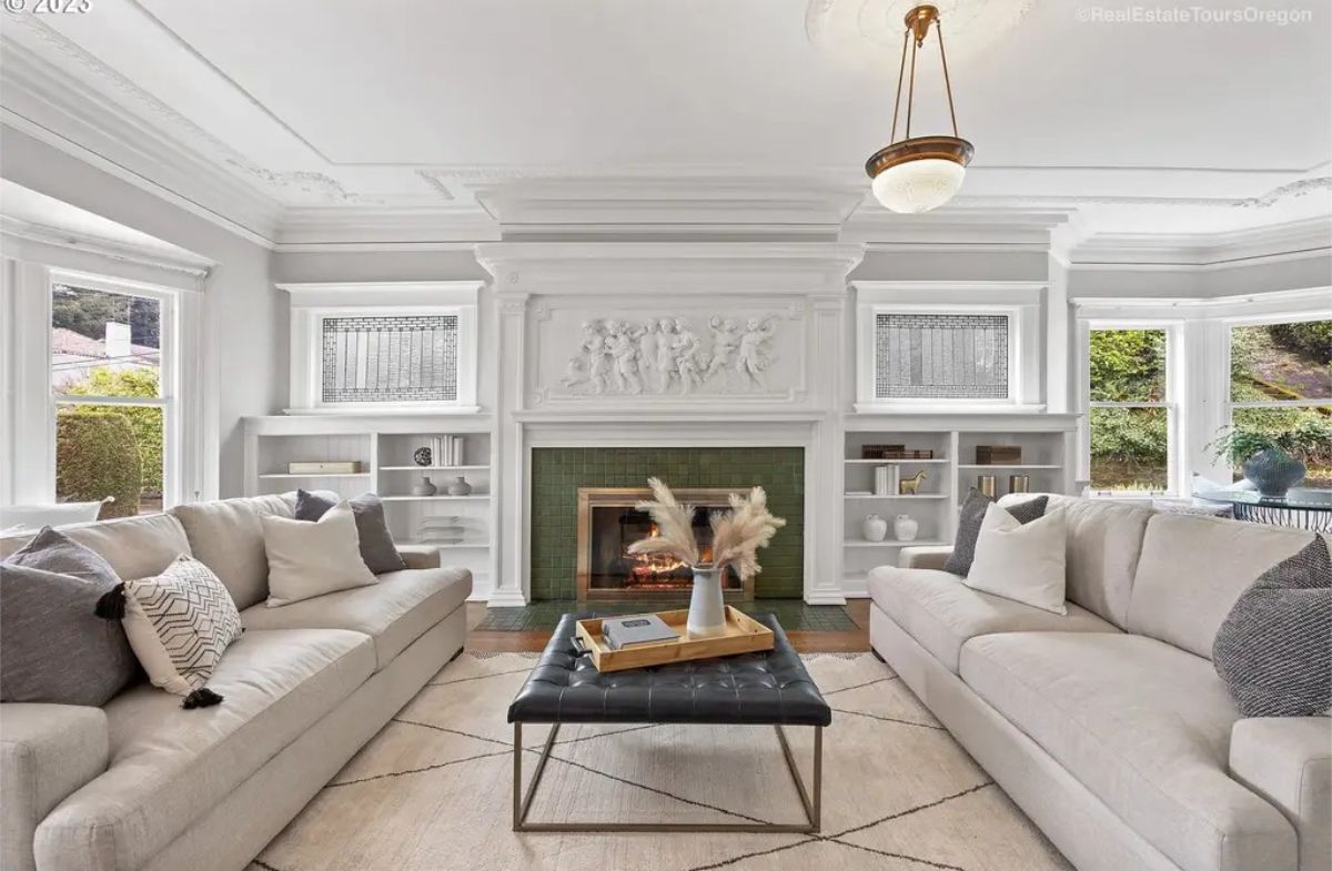 Living room features a stunning white fireplace adorned with intricate sculptural details.
