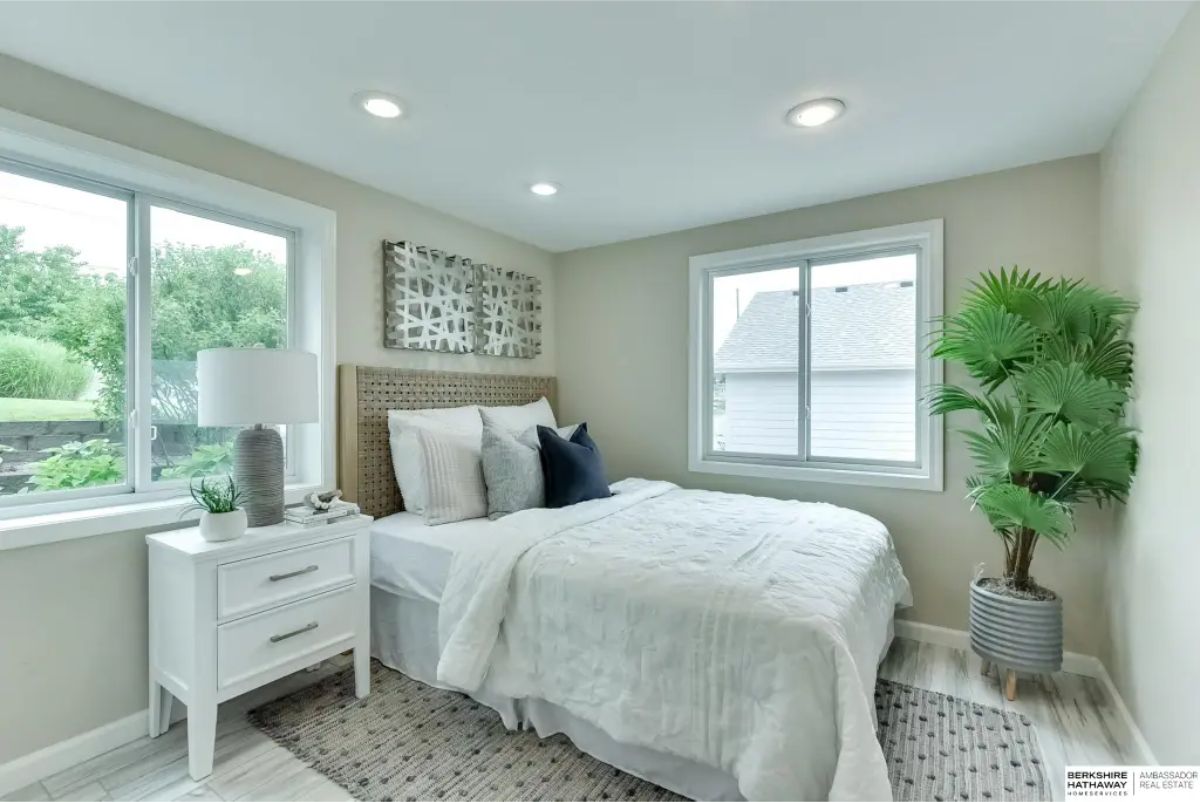 Bedroom designed with two large windows that bring in natural light and views of the outdoors.