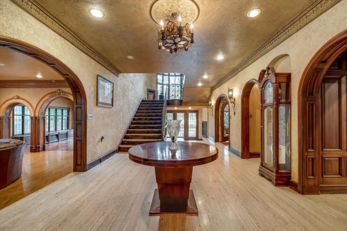Sophisticated entryway with a central wooden table and chandelier.