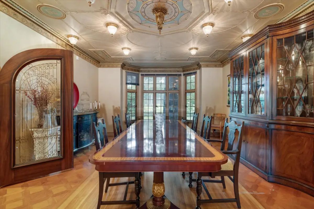 Presents a luxurious dining space with a polished wood table and high-back chairs.