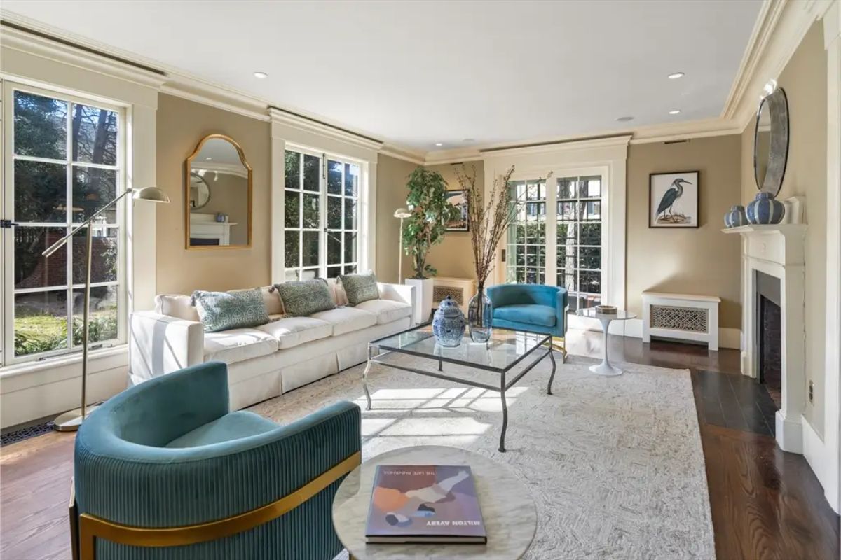 Living room boasts large windows and French doors, flooding the space with natural light and offering picturesque garden views.