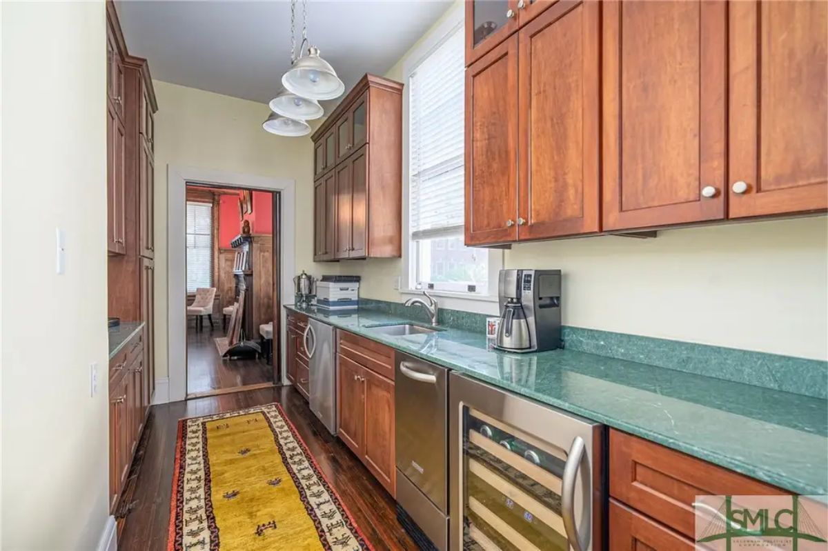 Streamlined galley kitchen featuring dark wood cabinetry and vibrant green countertops.