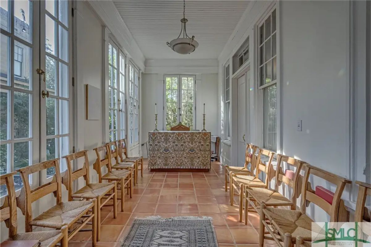 Long sunroom featuring terracotta tile floors and large windows for abundant natural light.
