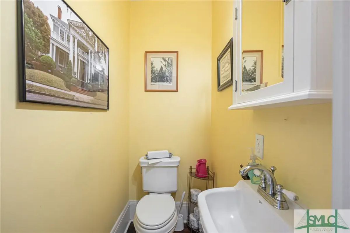 Small powder room featuring cheerful yellow walls and simple decor.