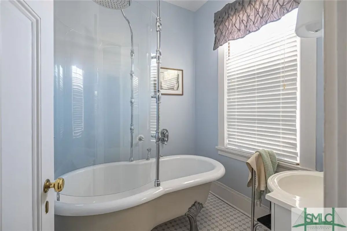 A clawfoot tub with a glass shower enclosure and polished chrome fixtures.
