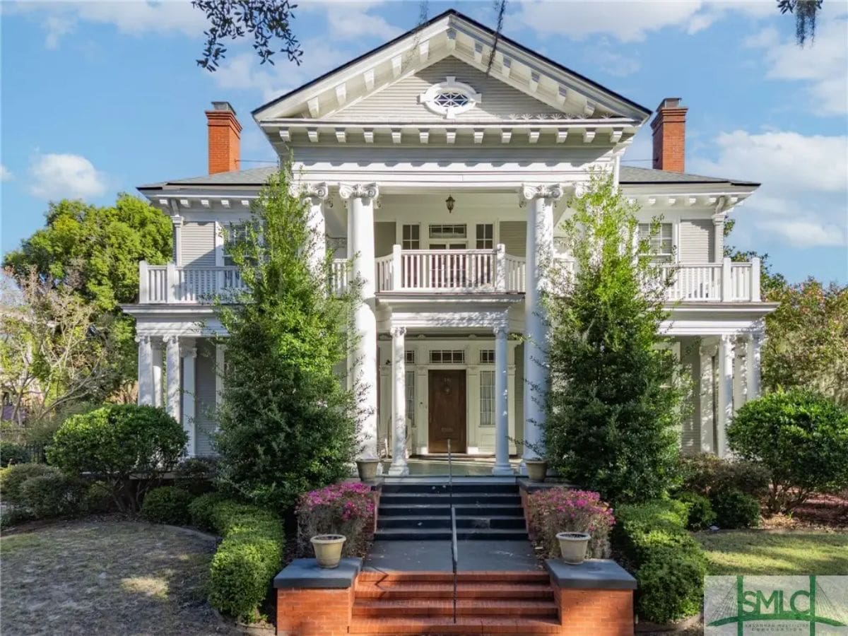 Two-story Greek Revival home with white columns and symmetrical architecture, built in 1882.