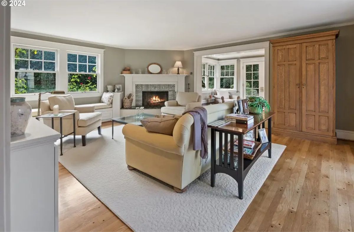 A cozy fireplace framed by white built-ins and soft gray walls.