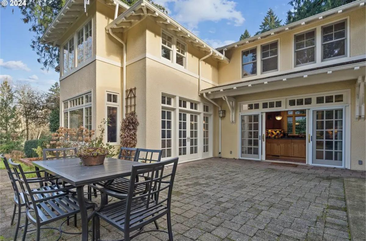 A paved surface and a black metal dining set for alfresco gatherings.
