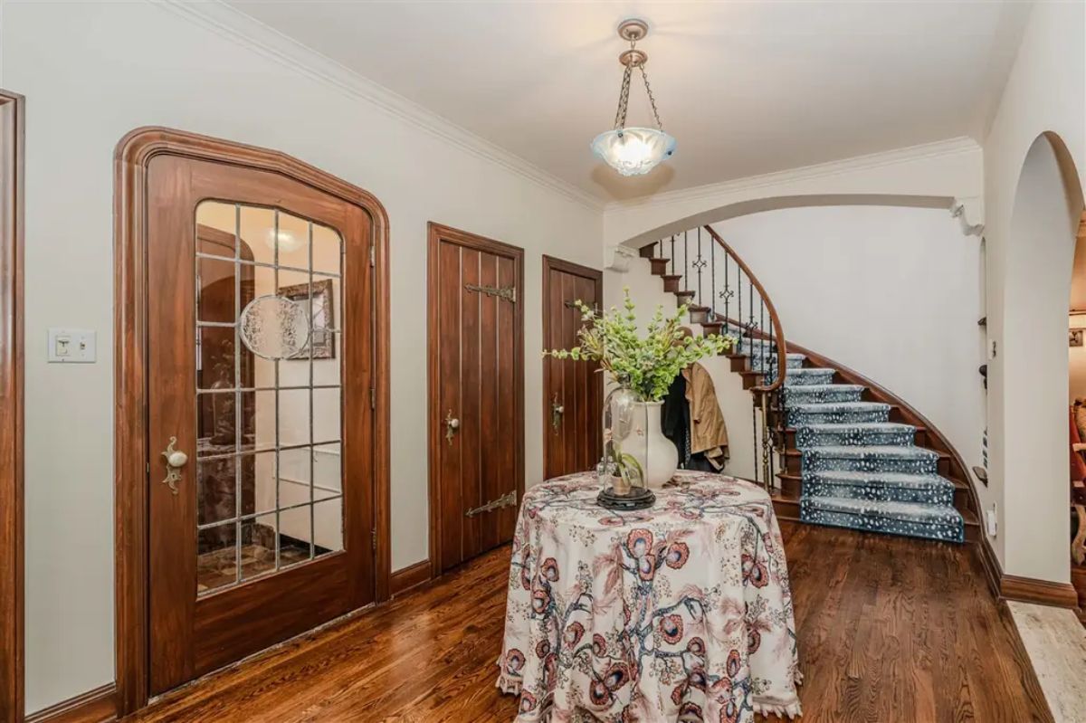 A graceful curved staircase with a patterned carpet runner and wrought iron railing.