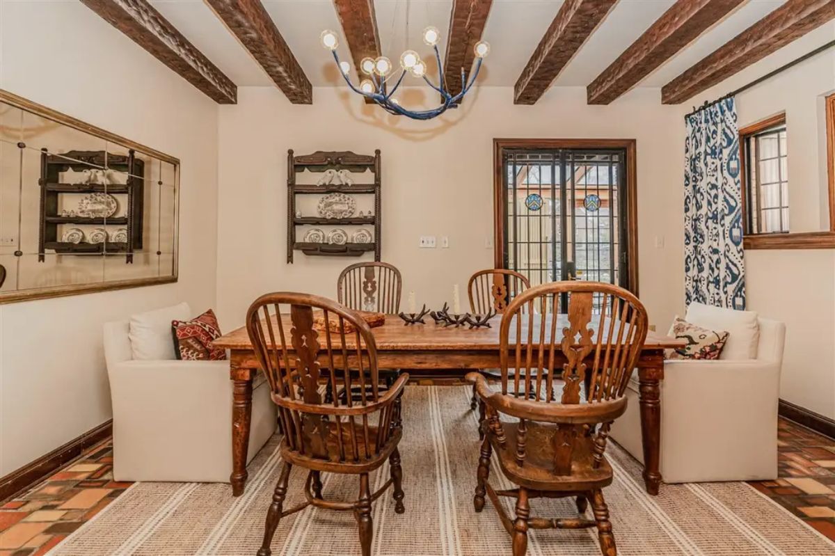 Wooden table surrounded by classic spindle-back chairs and upholstered seating.
