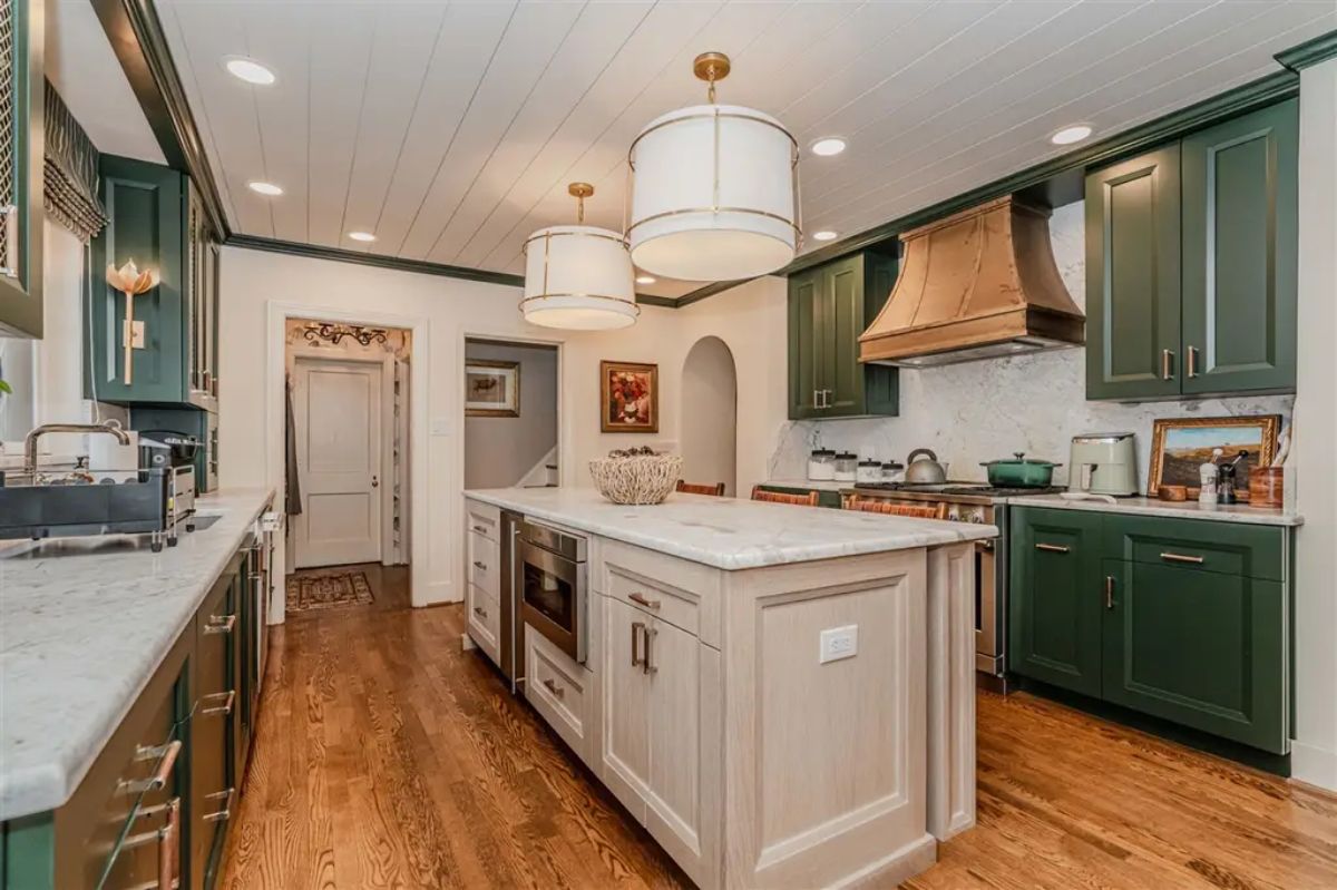 Deep green cabinetry paired with white marble countertops and backsplash.