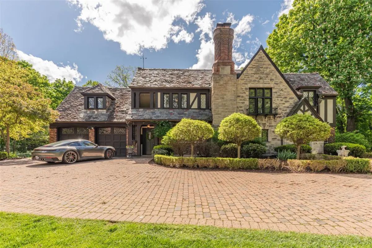 Exterior showcases classic Tudor architecture with a stone facade, pitched roof, and timber accents.