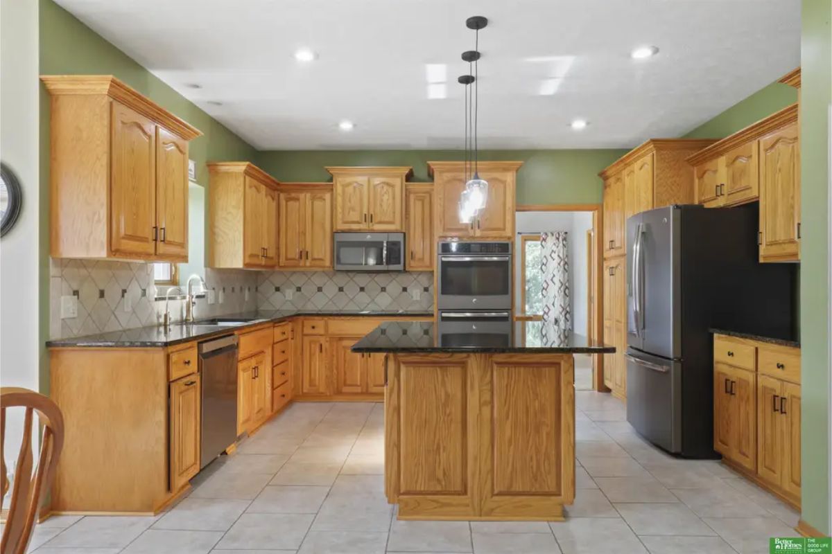 A warm wooden cabinetry and a sleek black granite countertop on the center island.