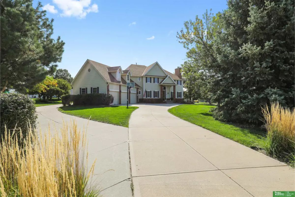 Two-story home is set on a spacious and well-manicured lot with mature trees and lush landscaping.